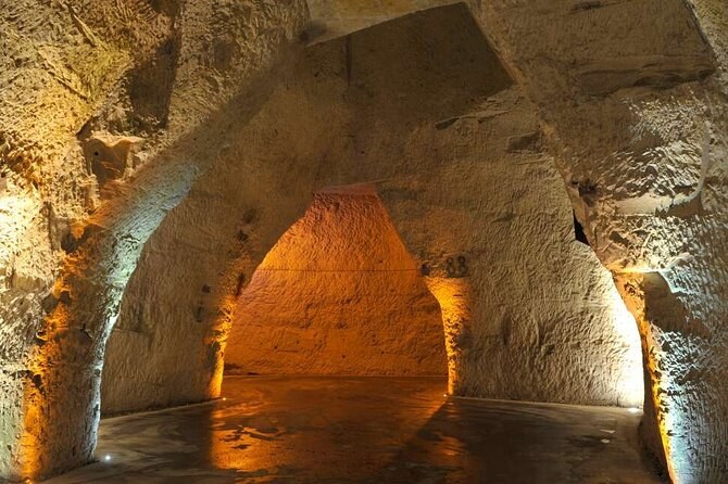 The pointed vault of a chalk pit, lit amber from below