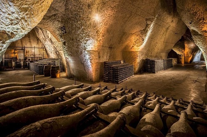Stacked bottles ageing in a high chalk cellar, its walls cut by hand