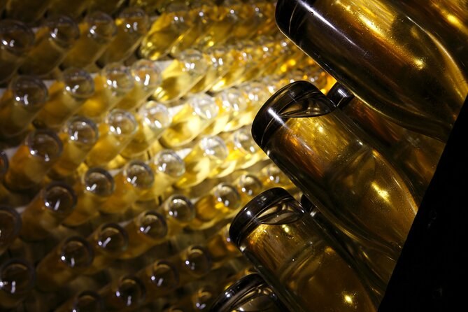 Bottles lying on their sides in the dark, their glass catching the light