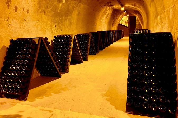 Riddling racks of bottles lining a long, lit chalk gallery under the ground